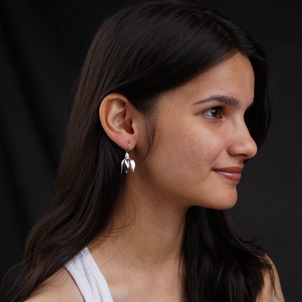 a close up of a person wearing a pair of earrings