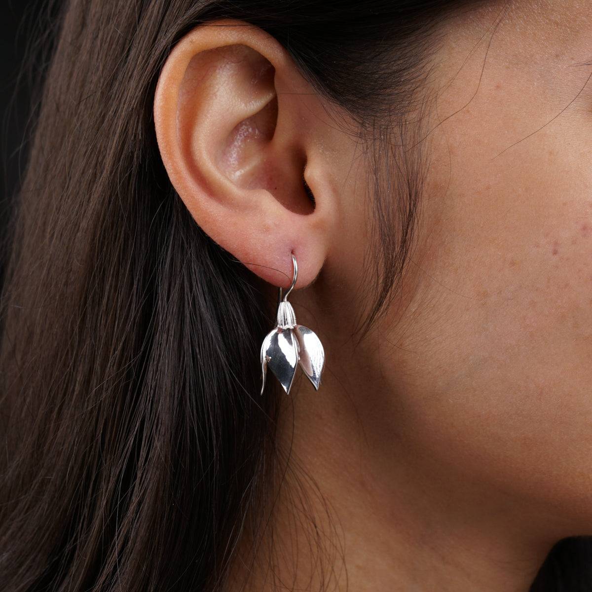 a close up of a person wearing a pair of earrings