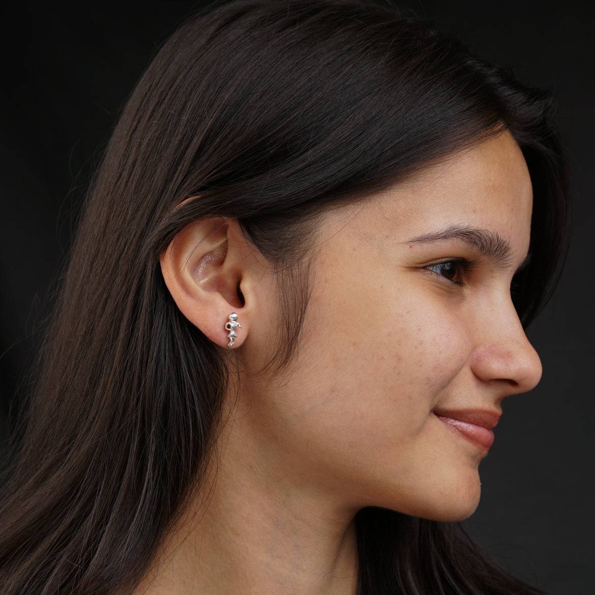 a close up of a person wearing a pair of earrings