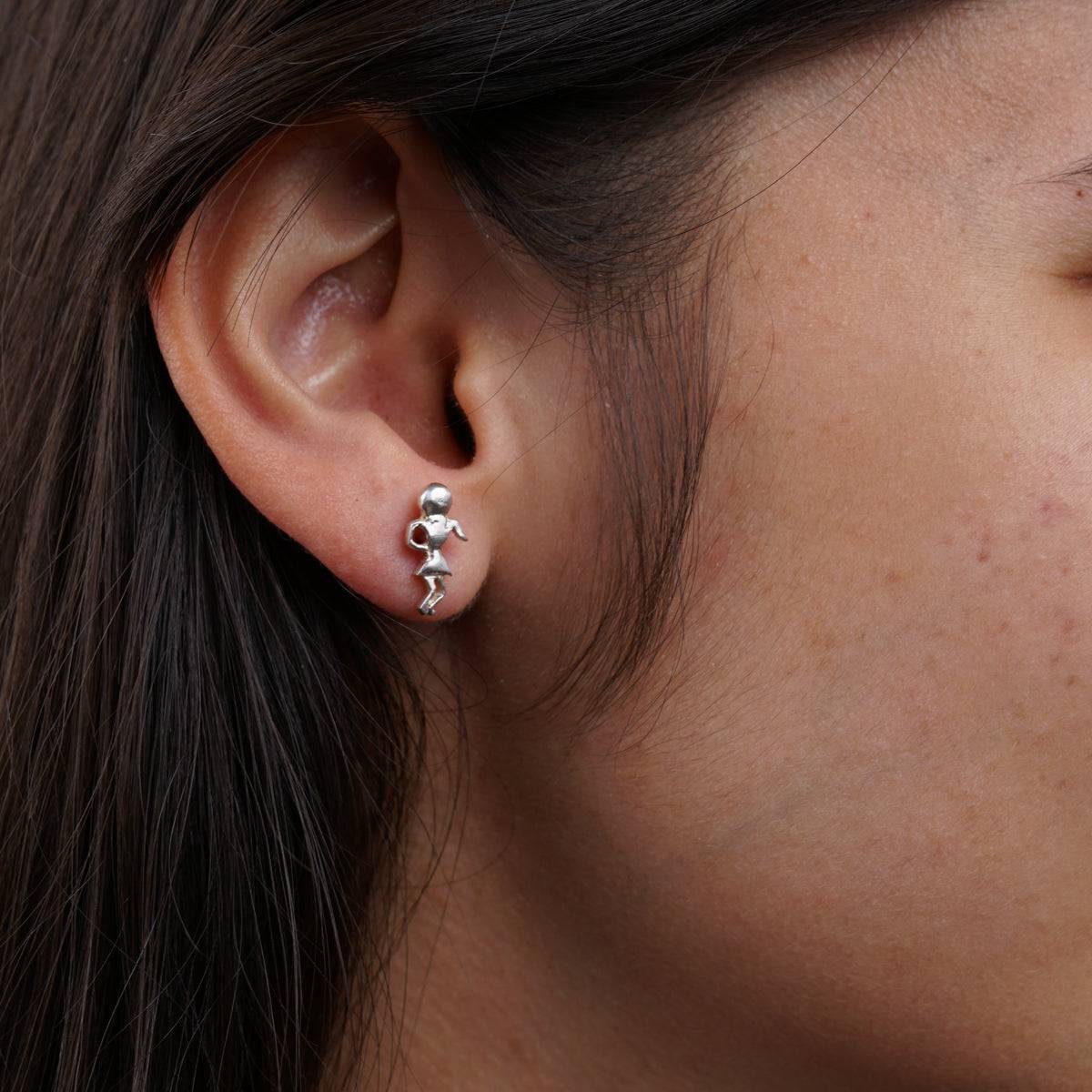 a close up of a person wearing a pair of earrings