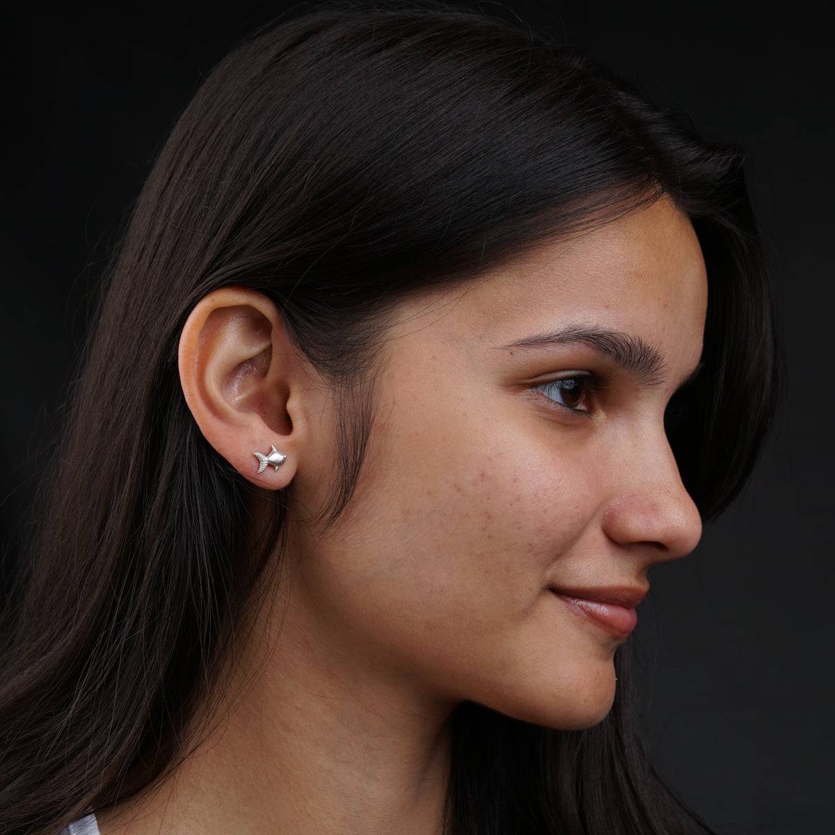 a close up of a person wearing a pair of earrings