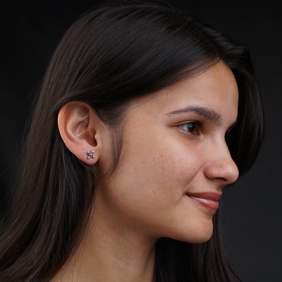 a close up of a person wearing a pair of earrings