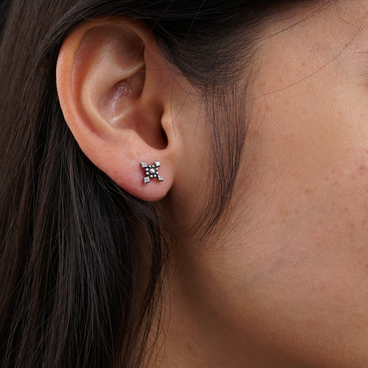 a close up of a person wearing a pair of earrings