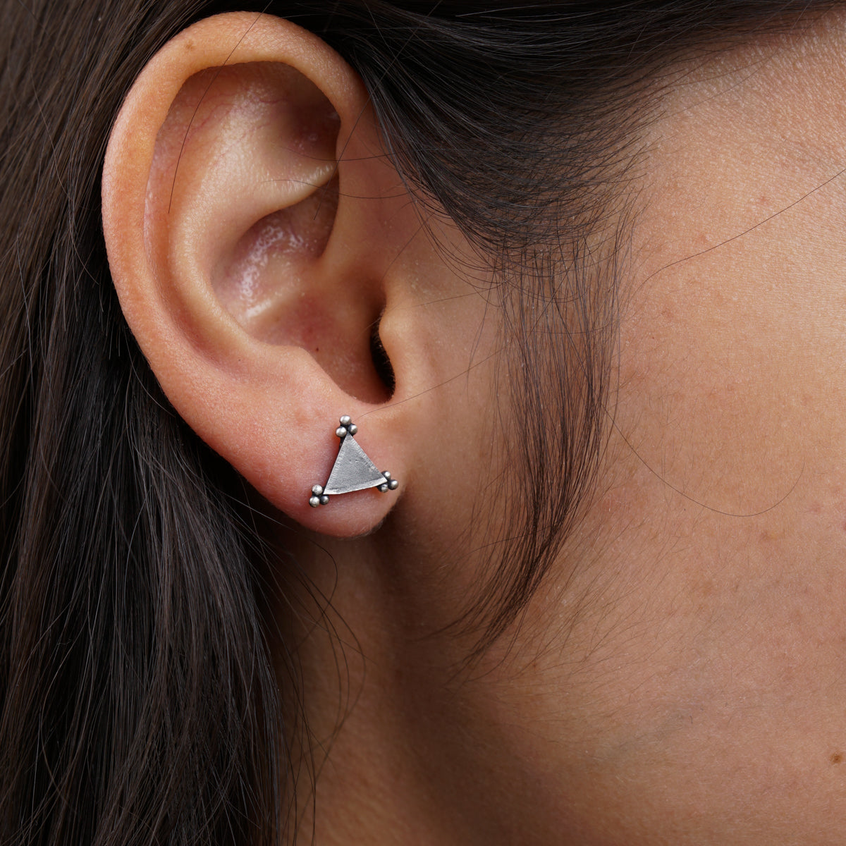 a close up of a person wearing a pair of earrings