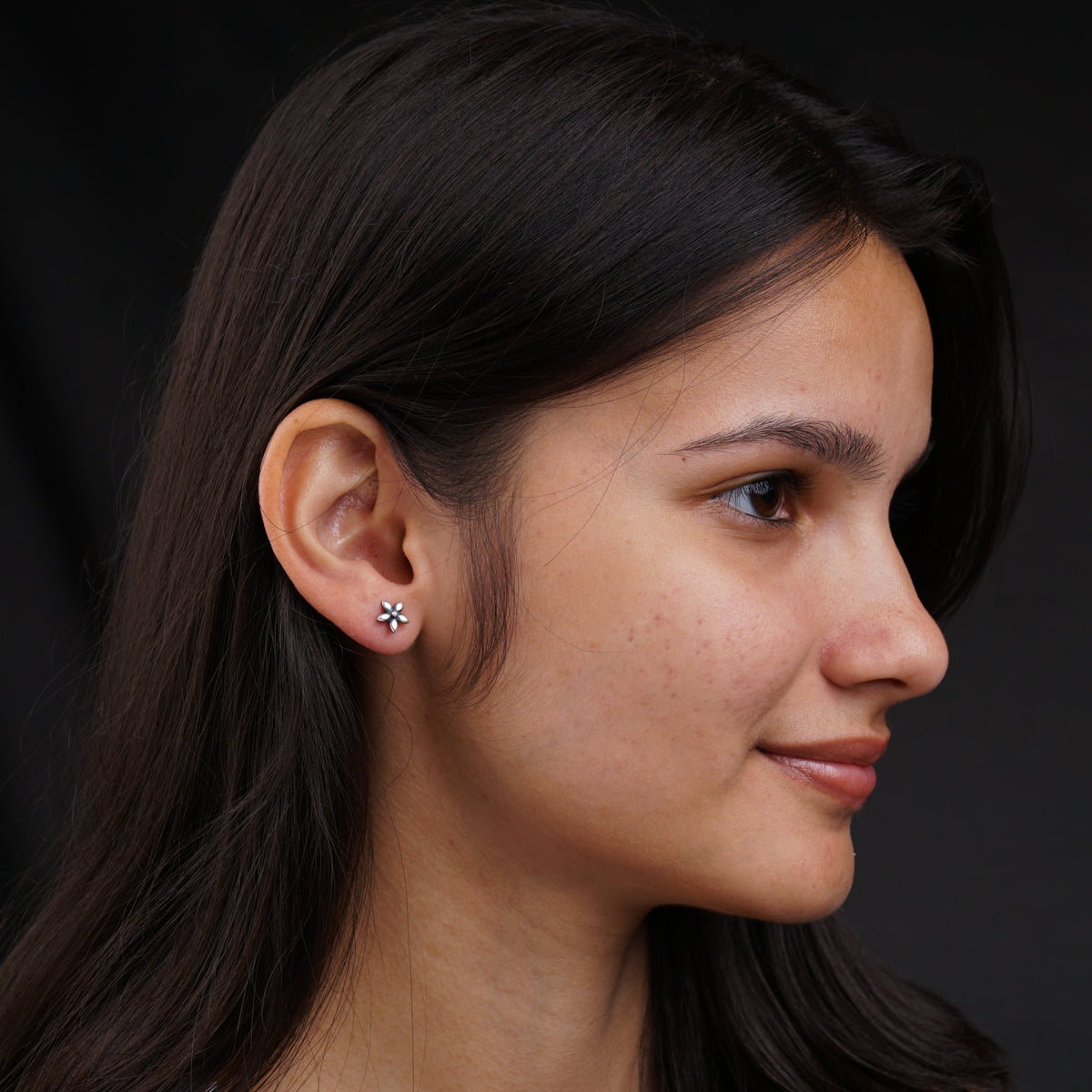 a close up of a person wearing a pair of earrings