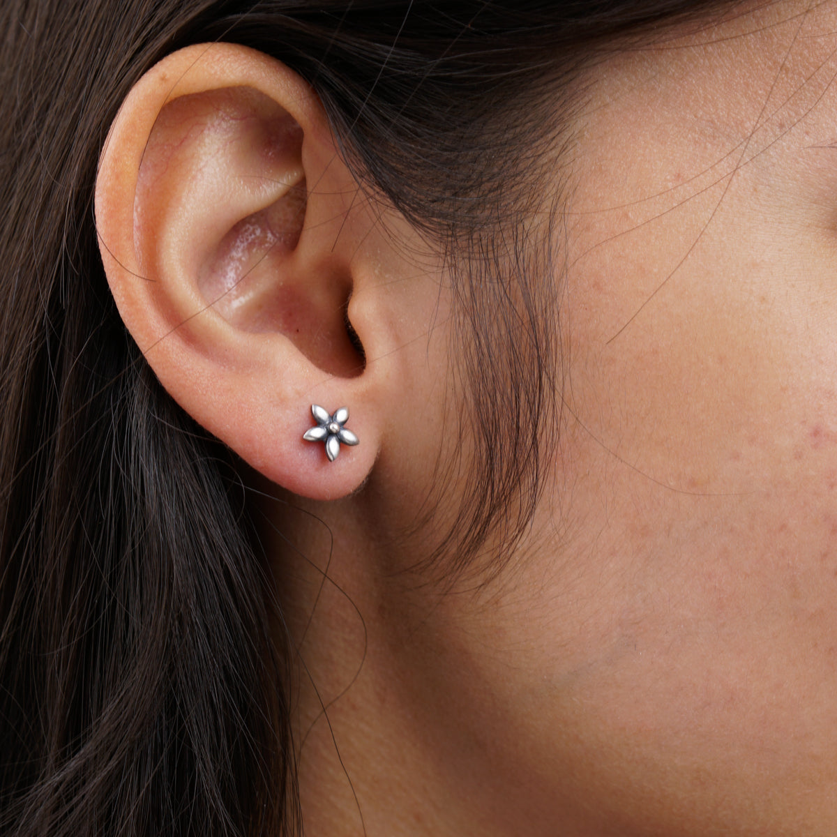 a close up of a person wearing a pair of earrings