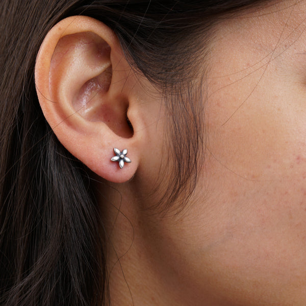 a close up of a person wearing a pair of earrings