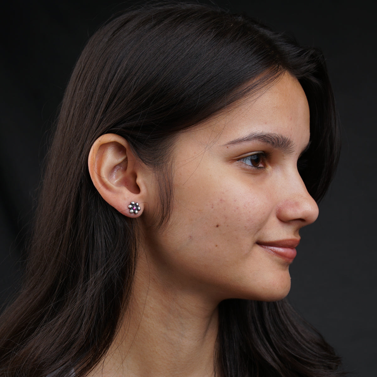 a close up of a person wearing a pair of earrings