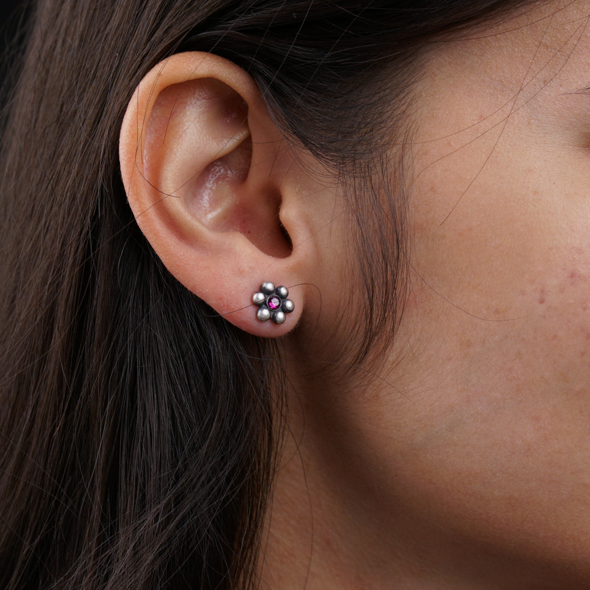 a close up of a person wearing a pair of earrings