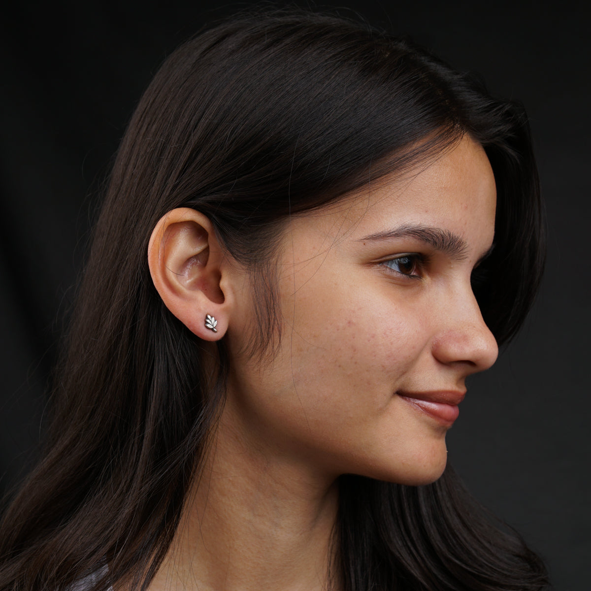 a close up of a person wearing a pair of earrings