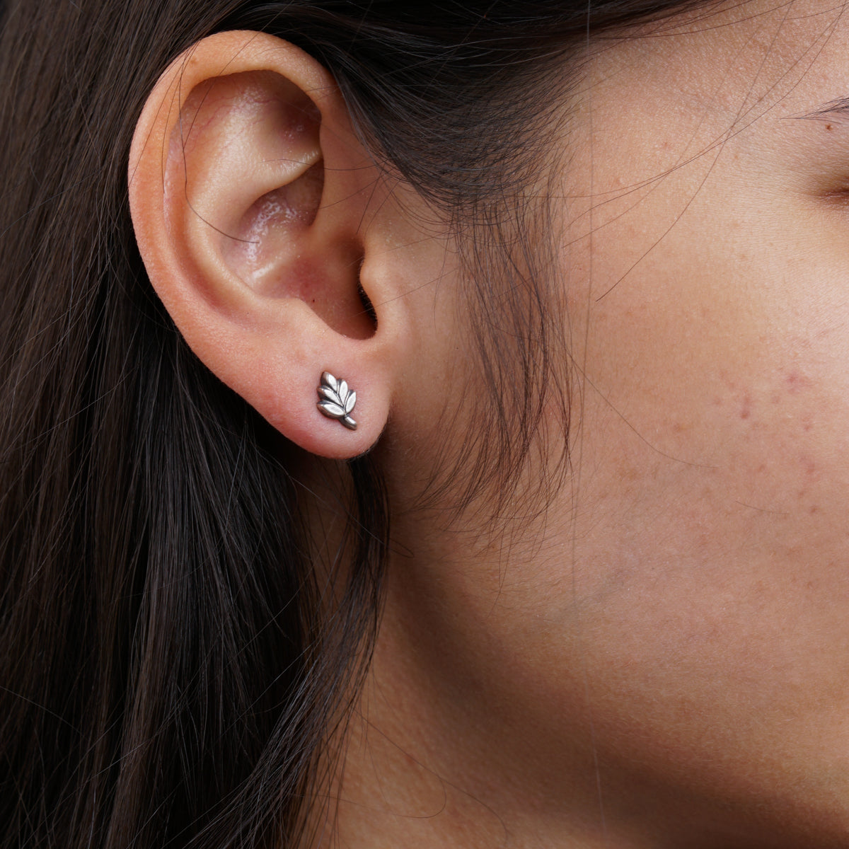 a close up of a person wearing a pair of earrings