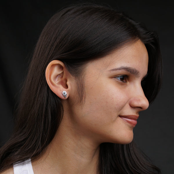 a close up of a person wearing a pair of earrings