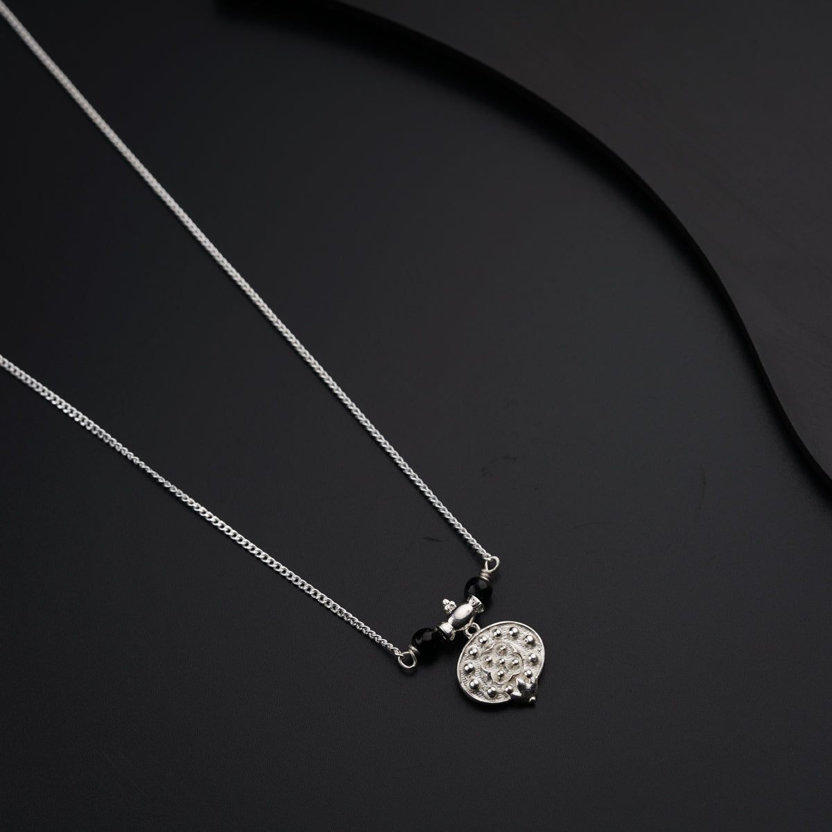 a black and white photo of two necklaces on a black surface