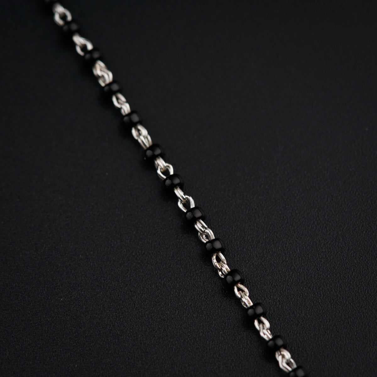 a close up of a chain on a black surface
