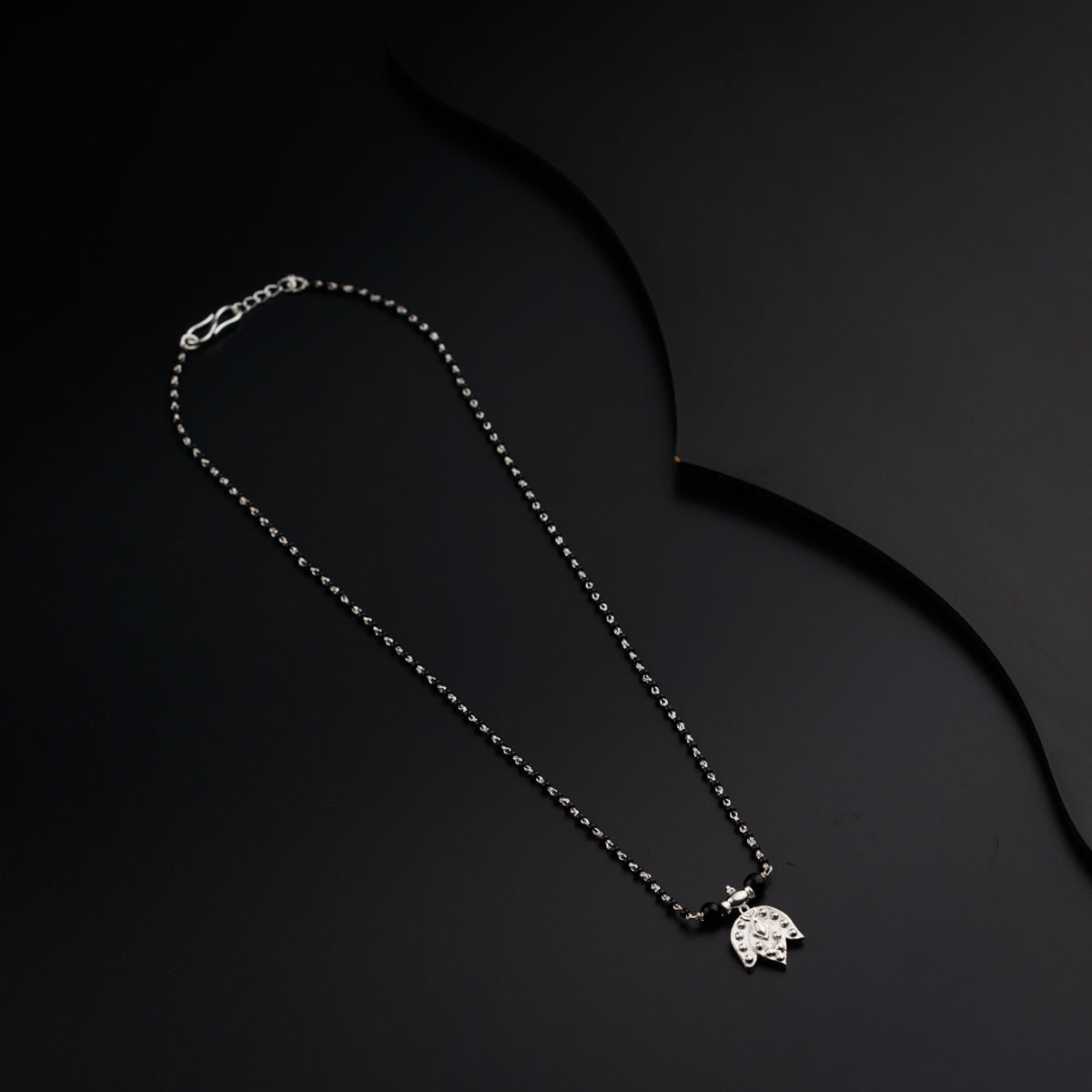 a silver necklace with a small turtle on it