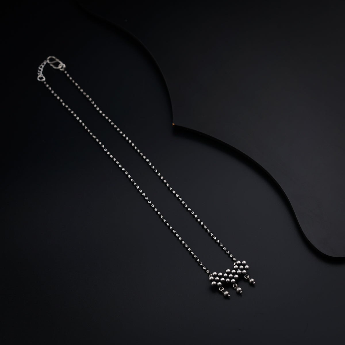 a necklace with a cross on it on a black surface