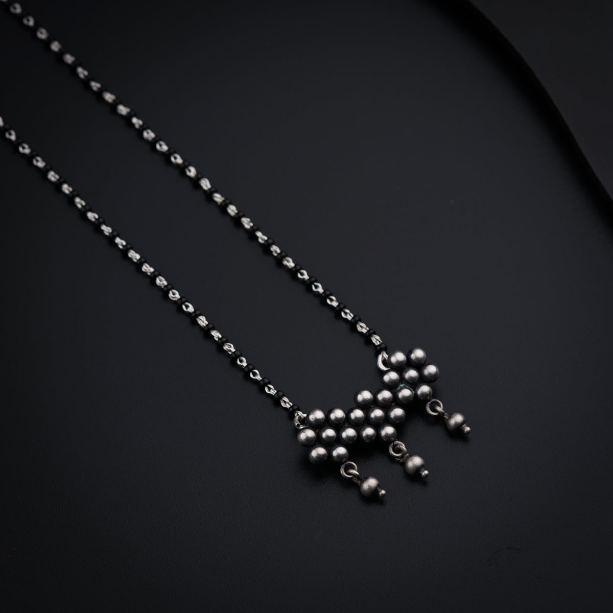 a black background with a silver ball chain