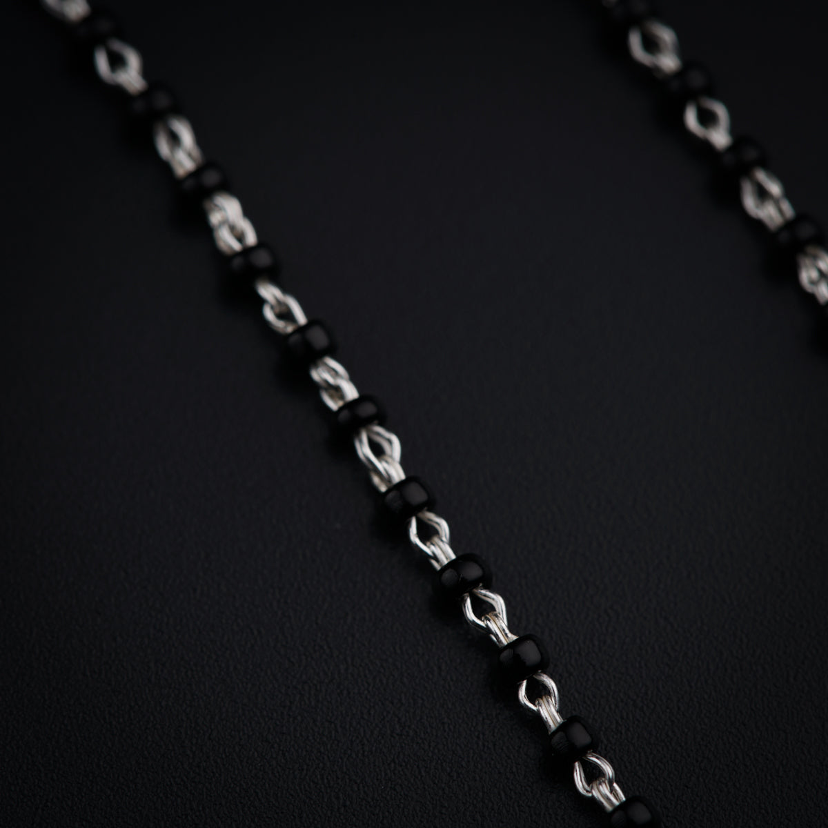 a close up of a black and silver necklace