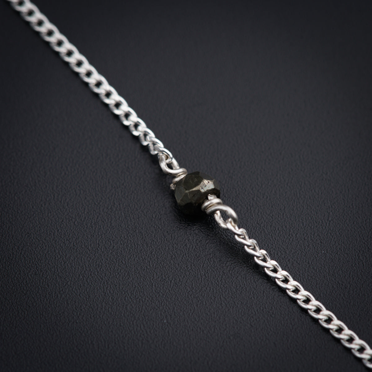 a close up of a chain on a black surface