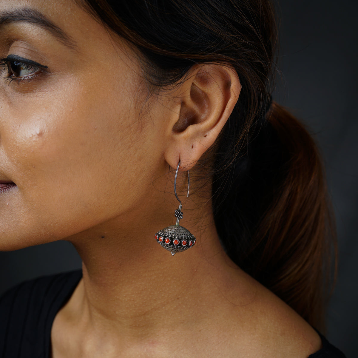 a close up of a person wearing a pair of earrings