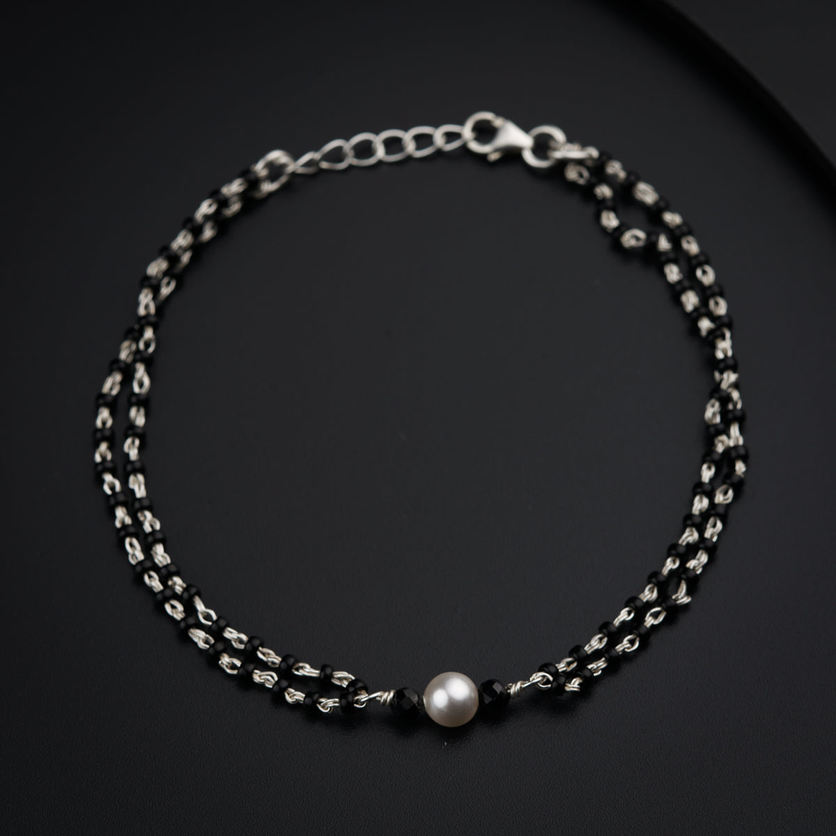 a black and silver bracelet with a pearl