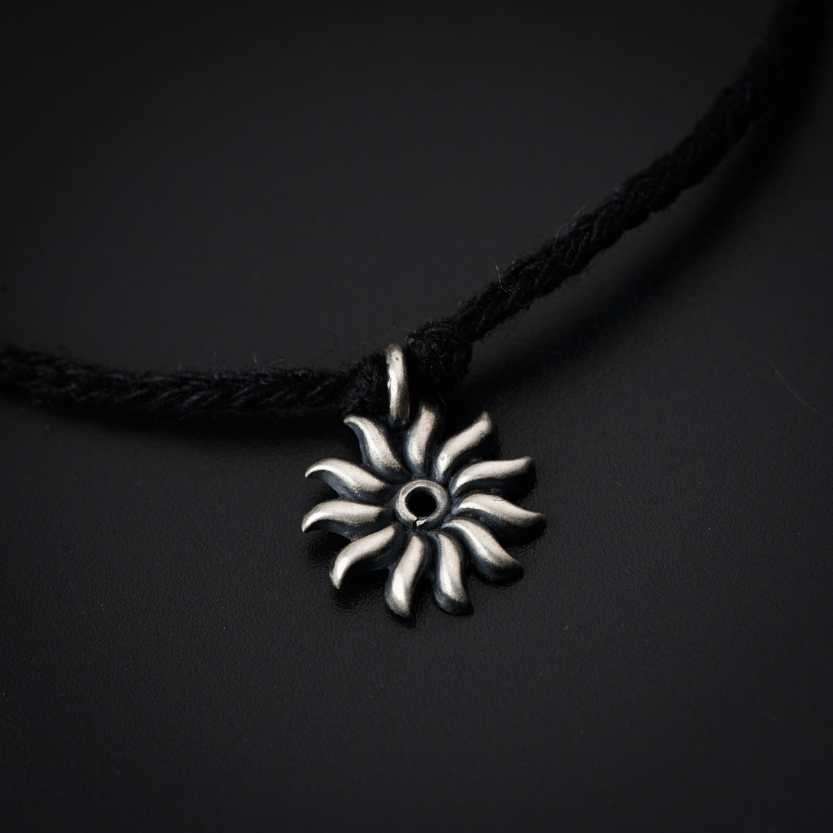 a black and white necklace with a flower on it