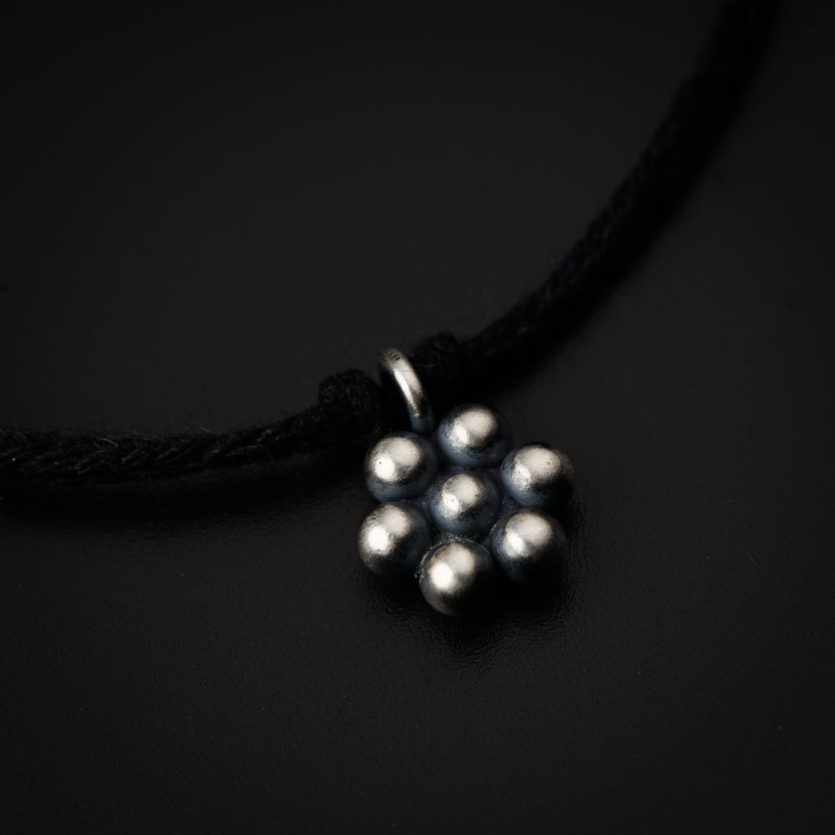 a black cord with a silver bead on it