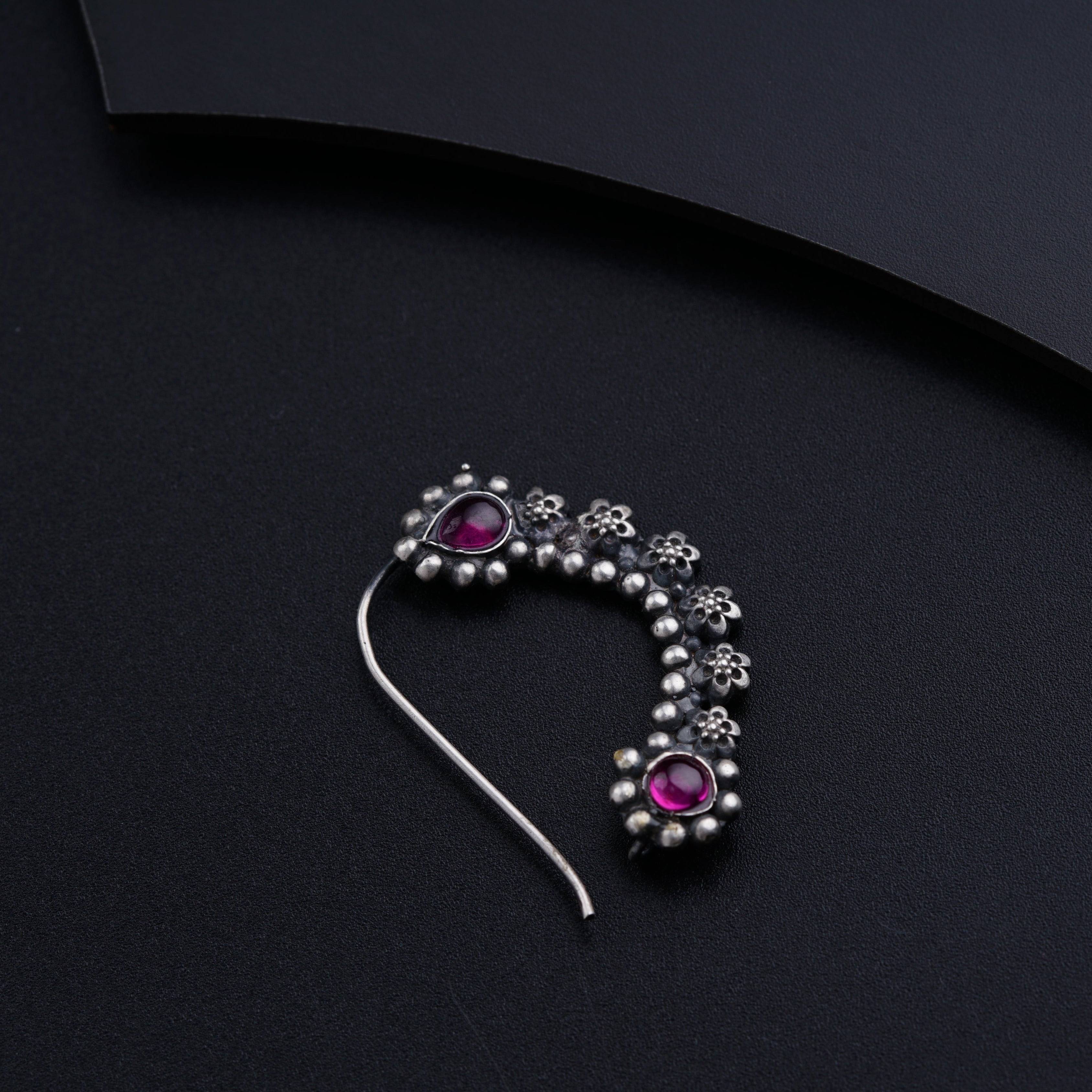 a close up of a brooch on a black surface