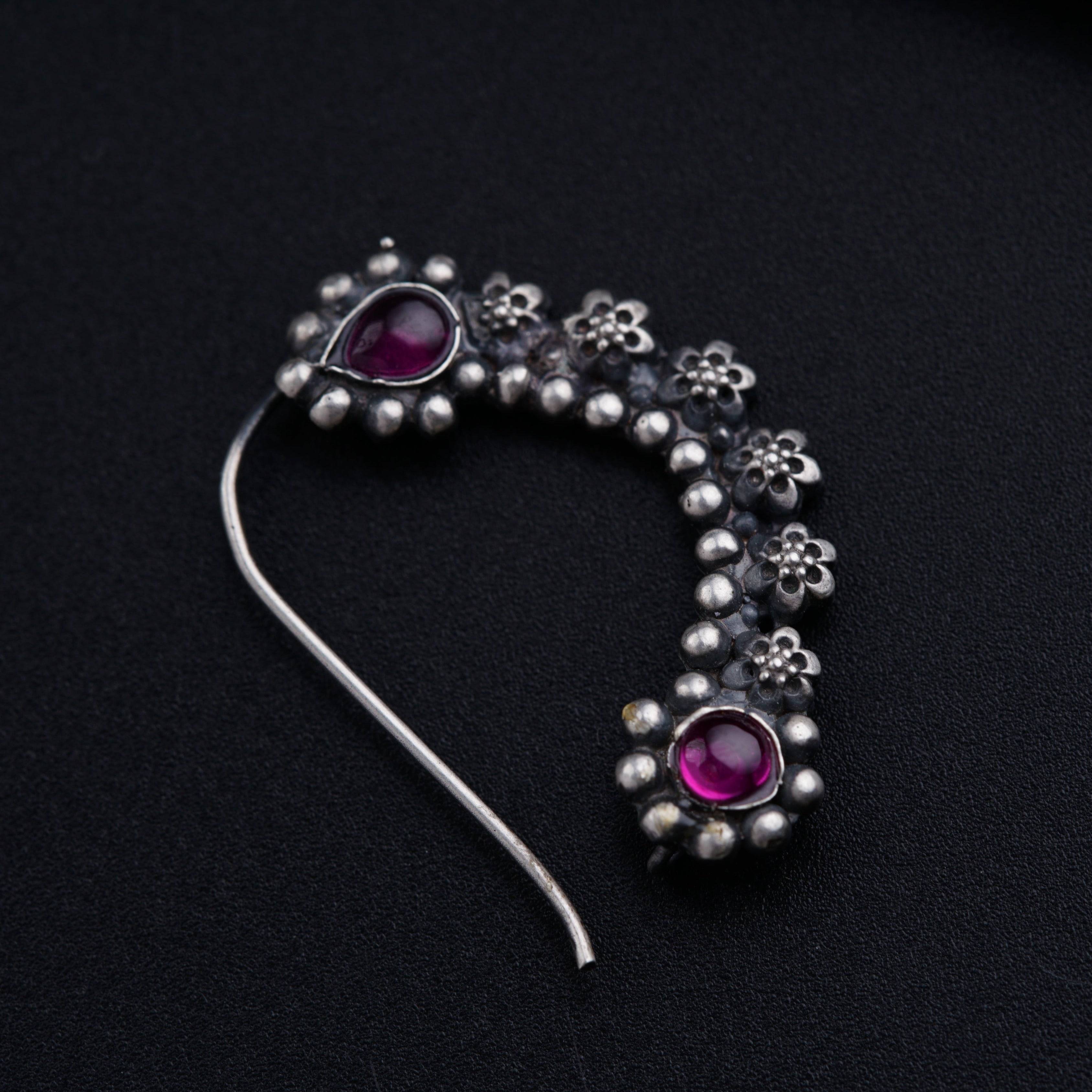 a close up of a piece of jewelry on a black surface