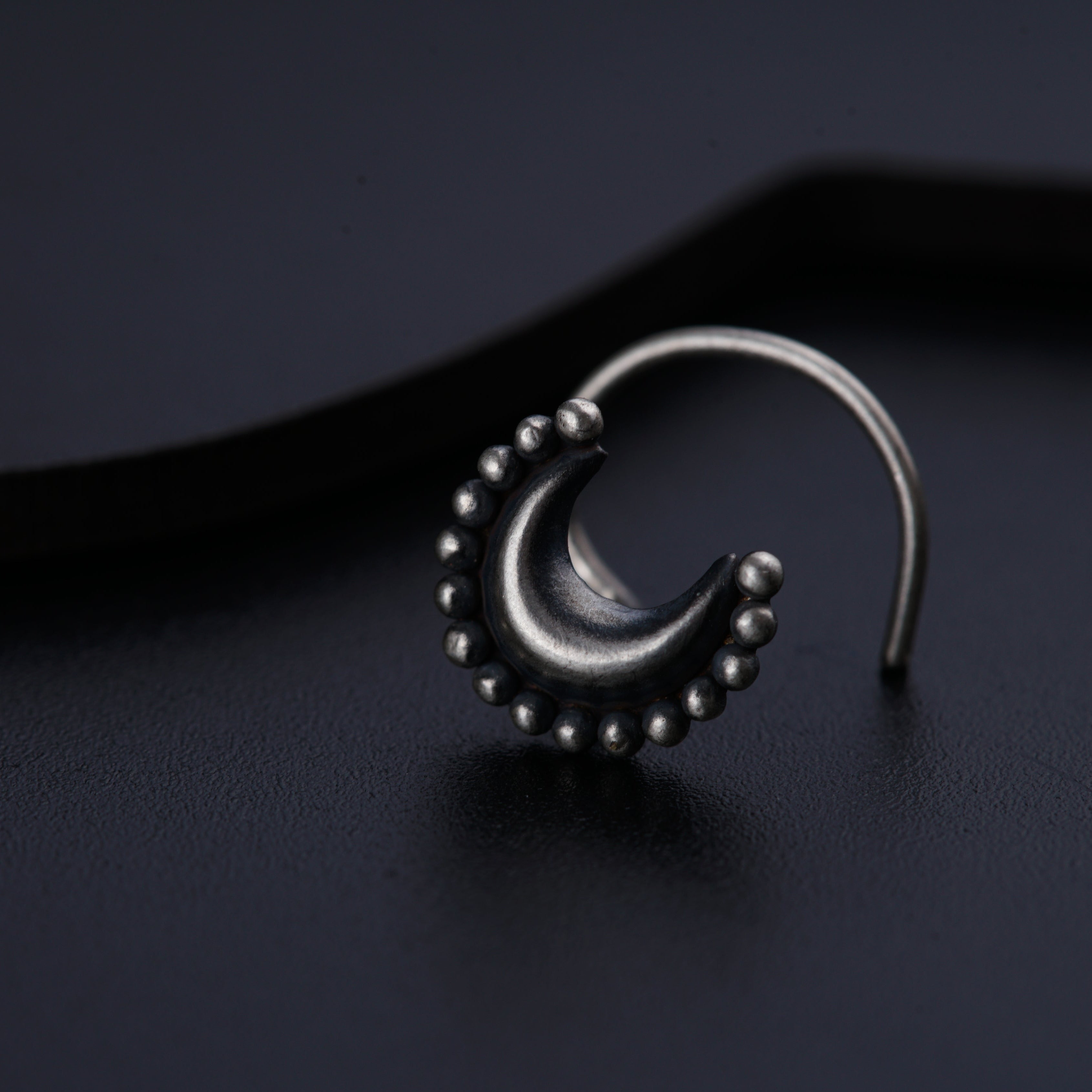 a close up of a pair of earrings on a black surface