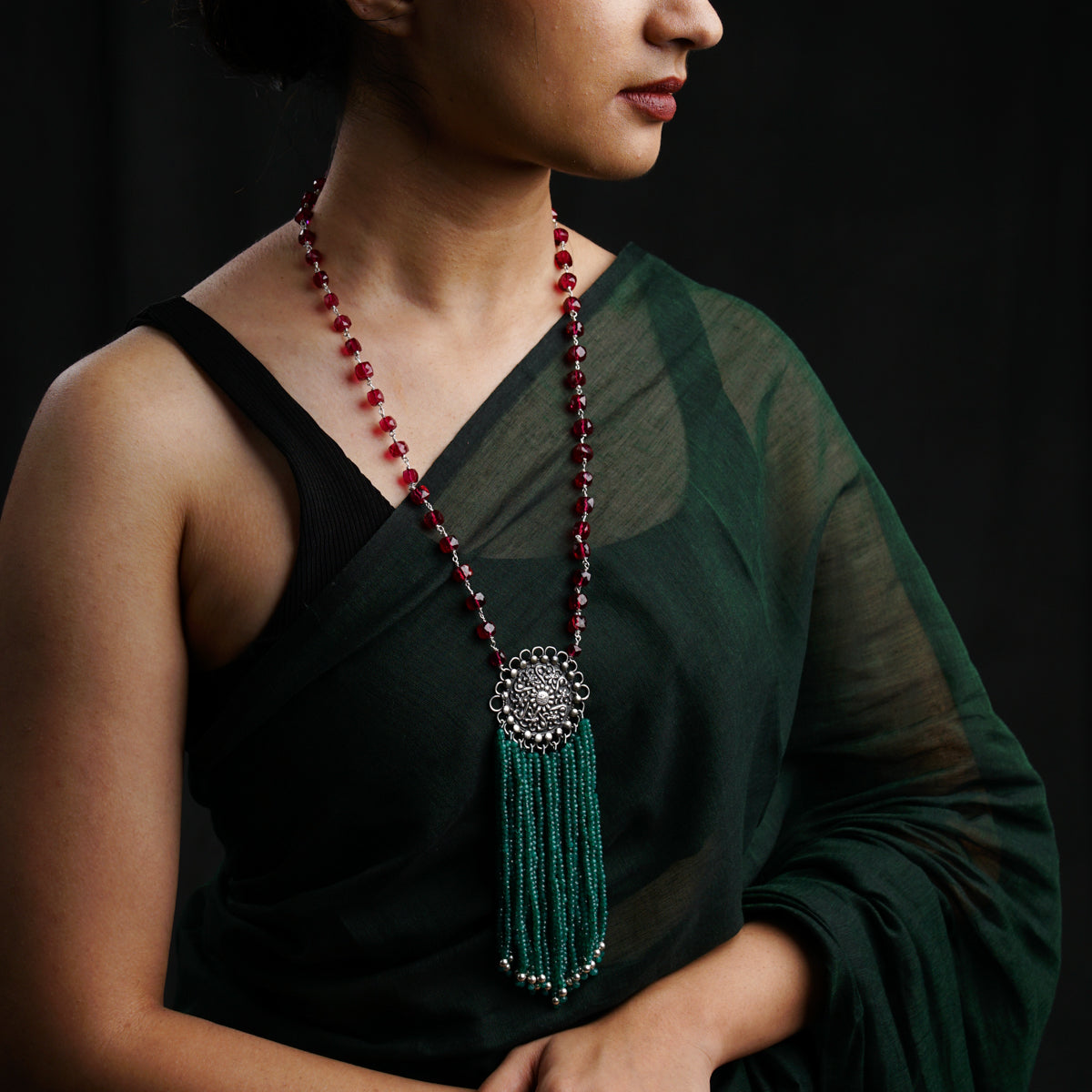 a woman wearing a necklace with a tassel