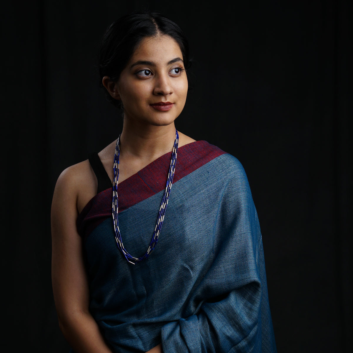 a woman in a sari with a necklace on her neck