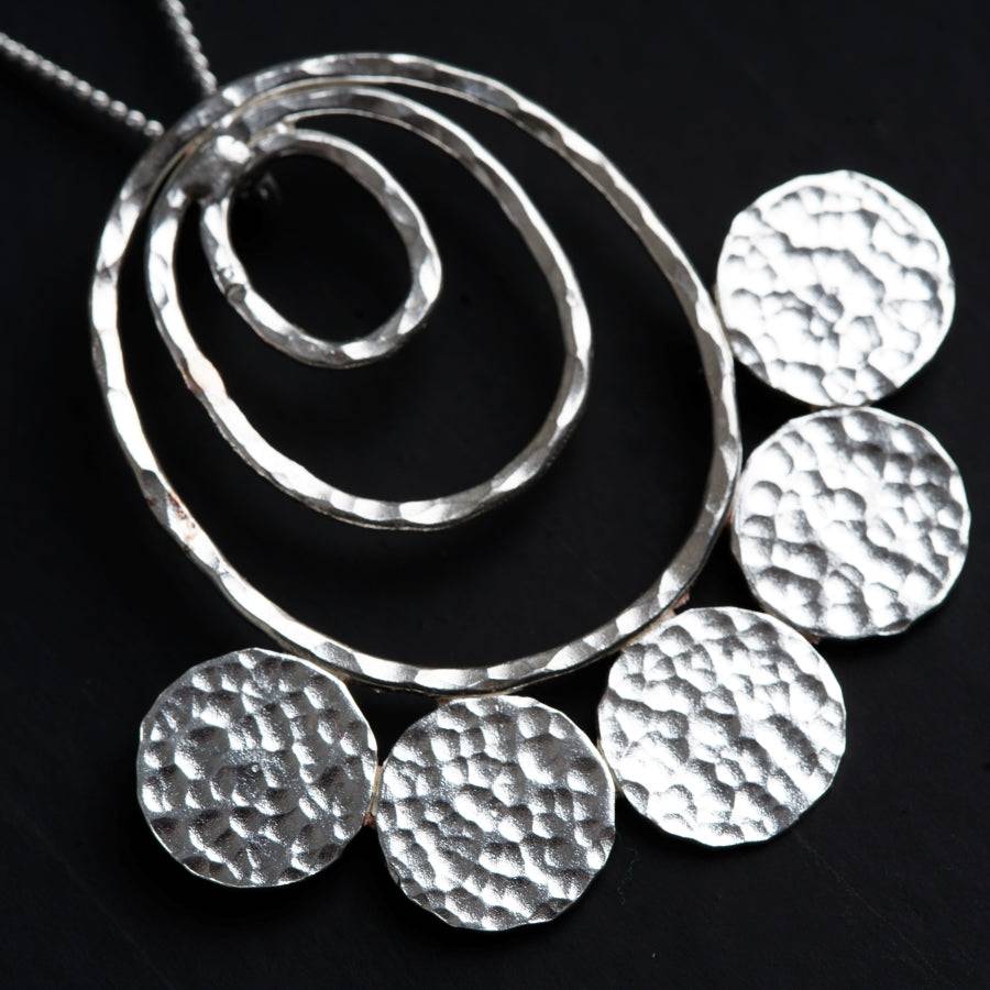 a close up of a necklace on a black surface