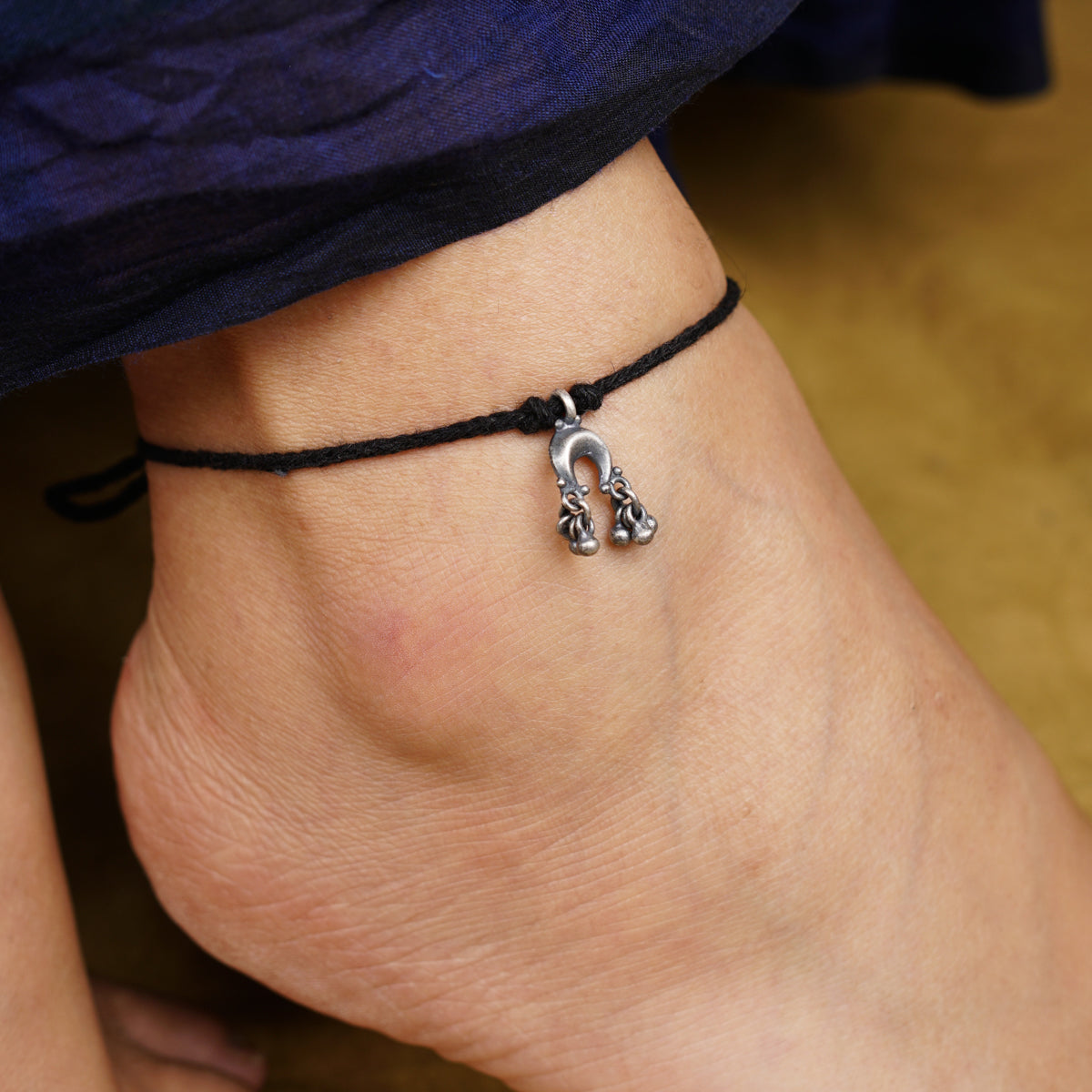 a close up of a person's foot wearing a bracelet