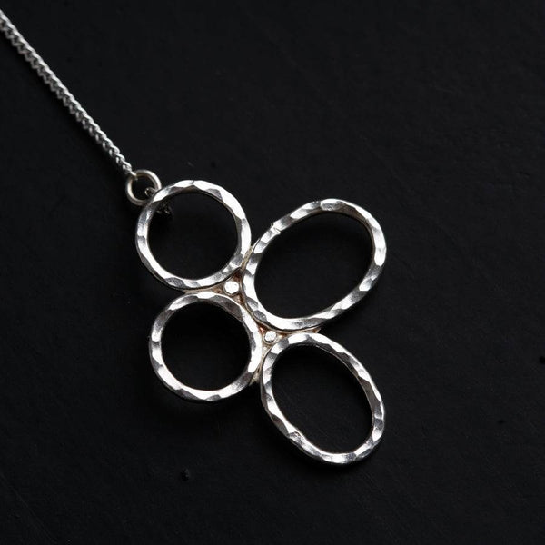 a silver necklace on a black surface