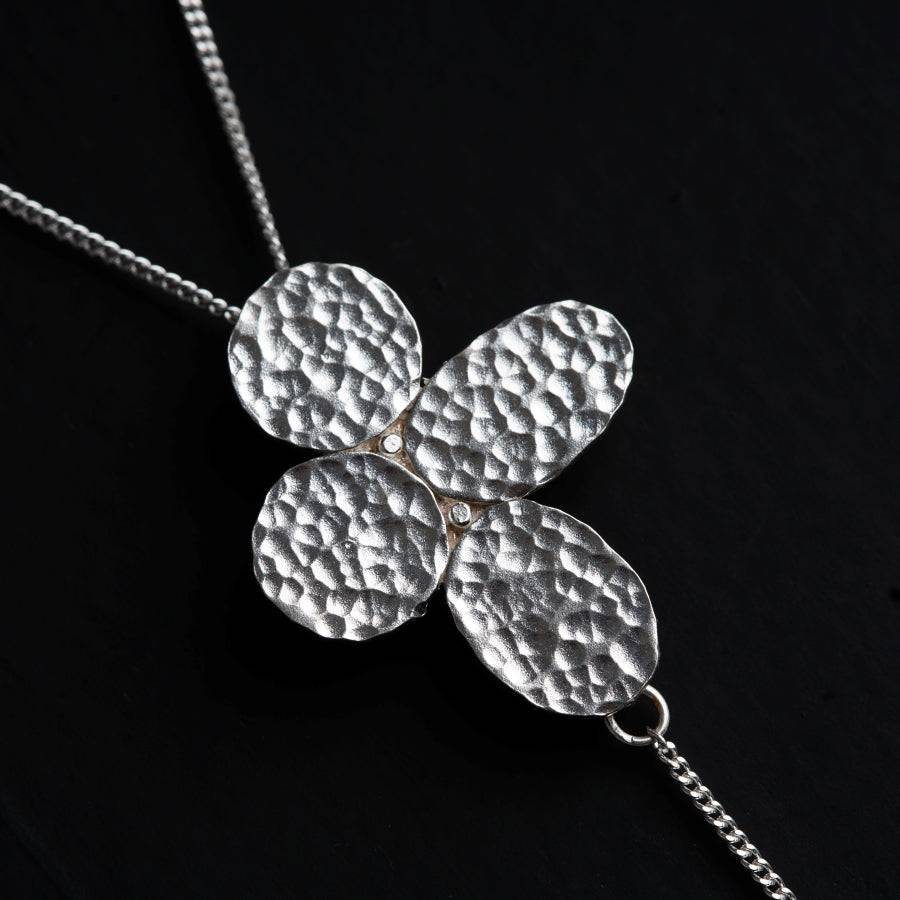 a four leaf clover necklace on a black background