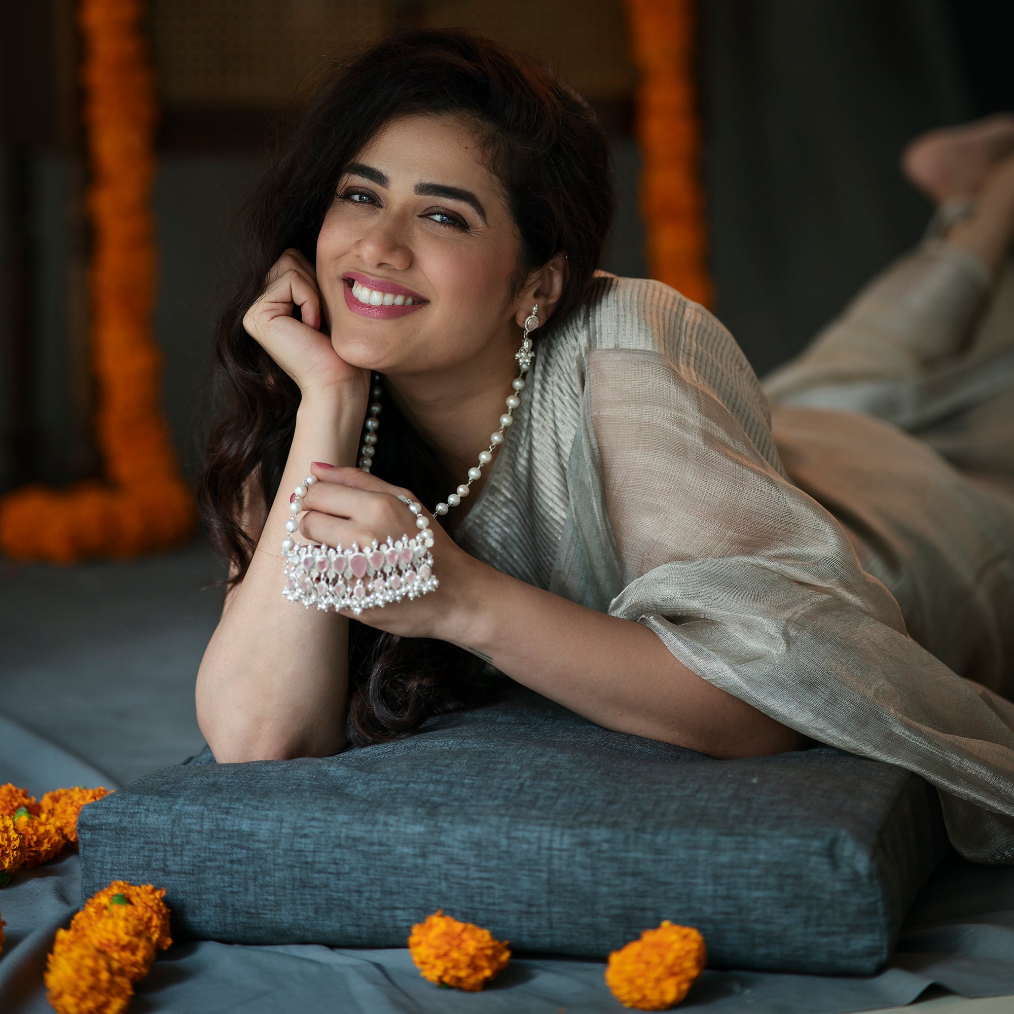 a woman laying on top of a bed next to flowers