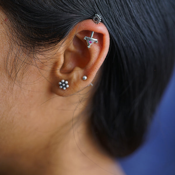 a close up of a person wearing a pair of ear piercings