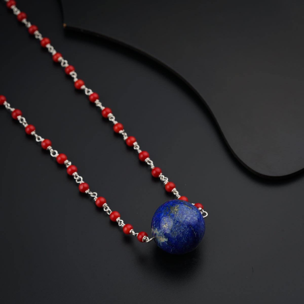 a necklace with a blue bead and a red bead