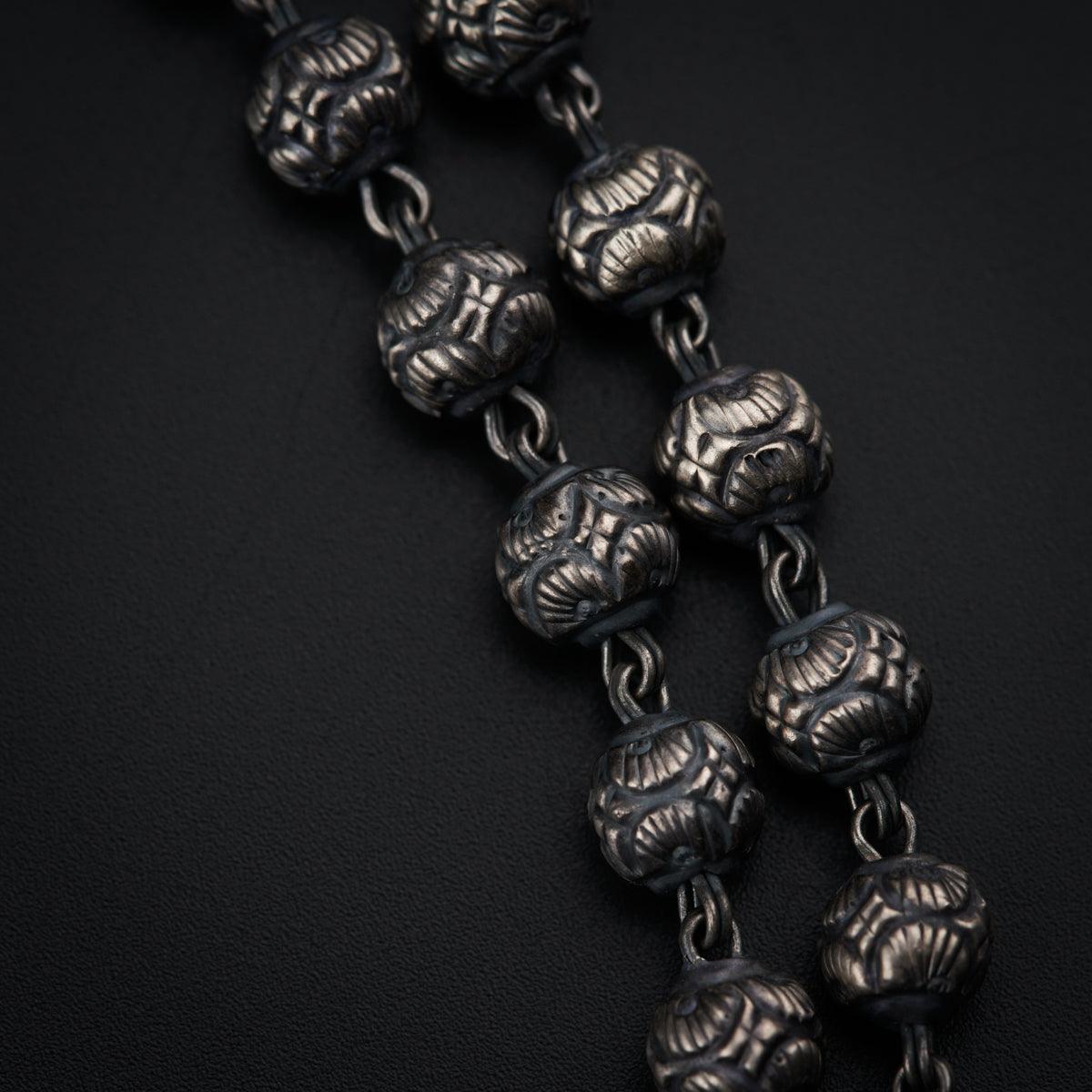 a close up of a metal chain on a black surface