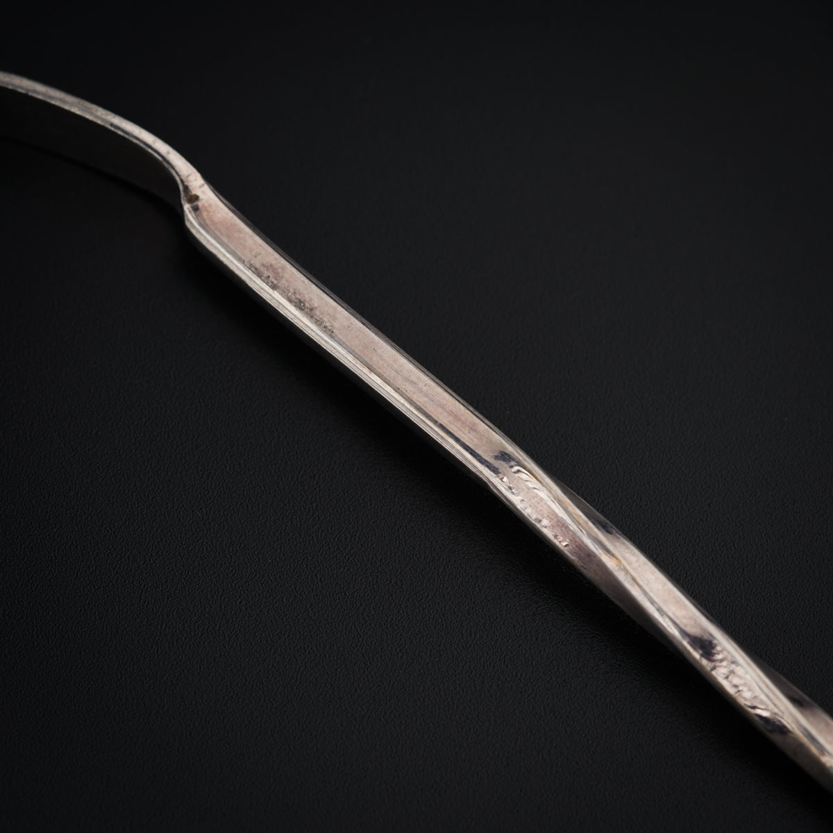 a silver fork on a black surface