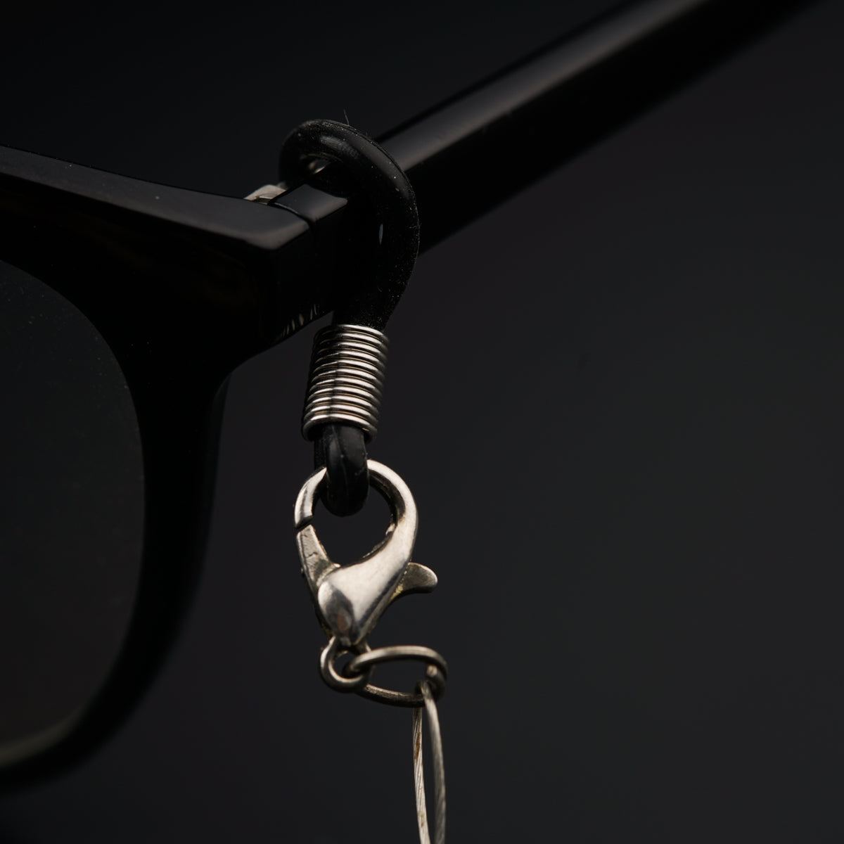 a close up of a pair of glasses with a chain attached to it