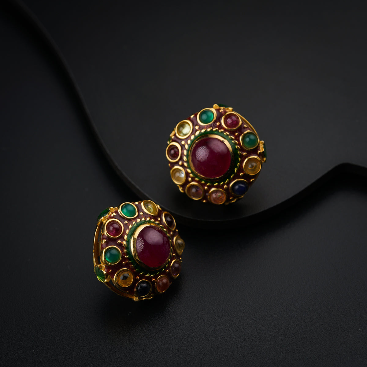 a close up of a pair of earrings on a black surface
