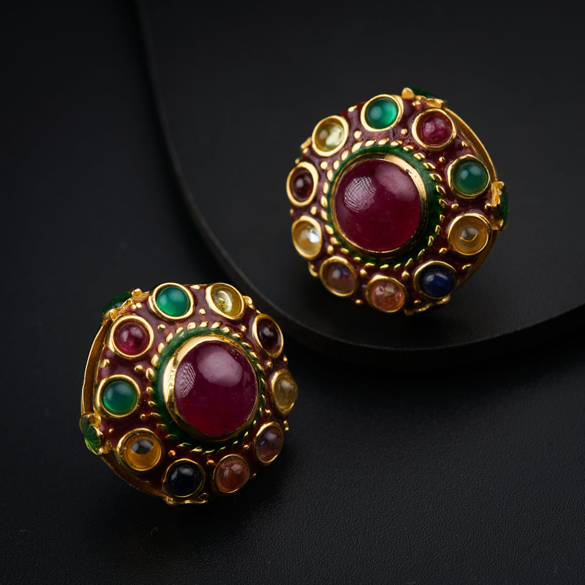 a close up of a pair of earrings on a black surface