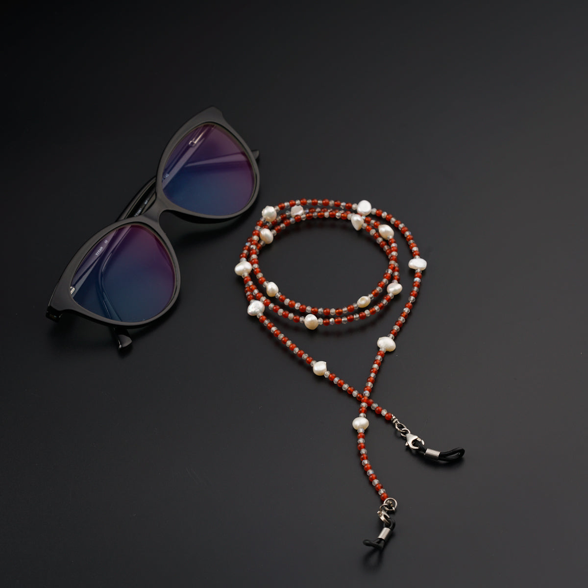 a pair of sunglasses and a beaded necklace