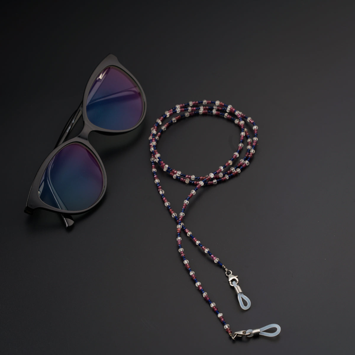a pair of sunglasses and a lanyard on a black surface
