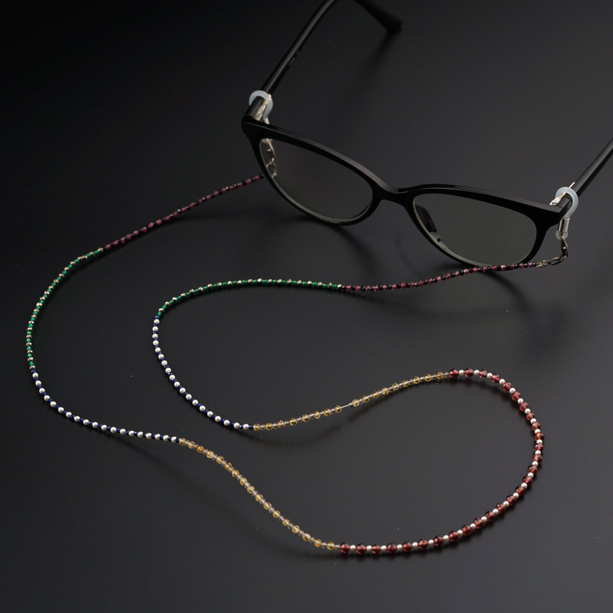 a pair of glasses with beads on a black background