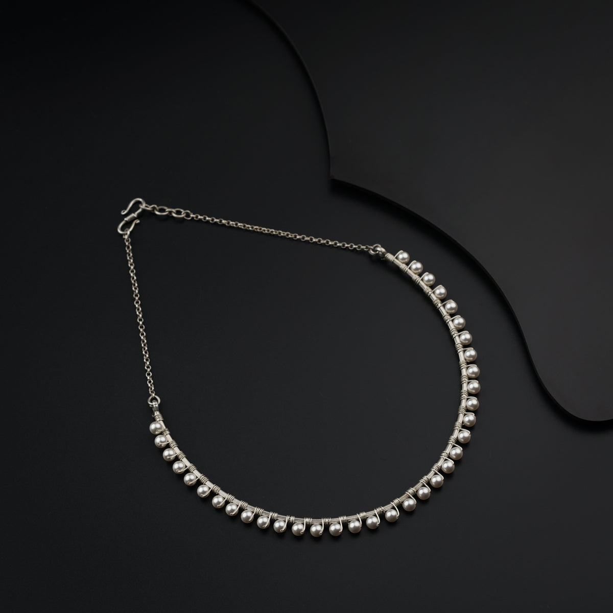 a close up of a necklace on a black surface