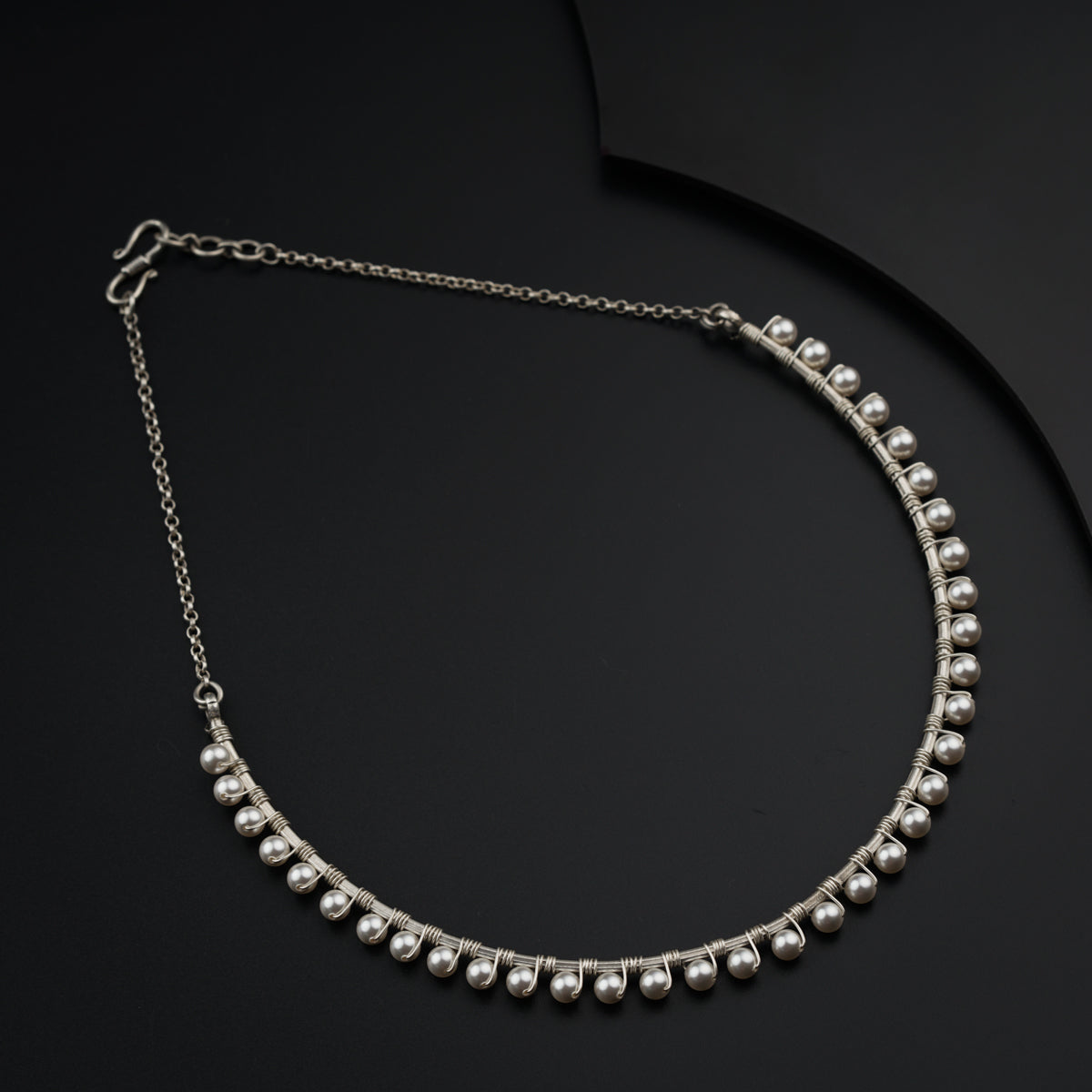 a close up of a necklace on a black surface
