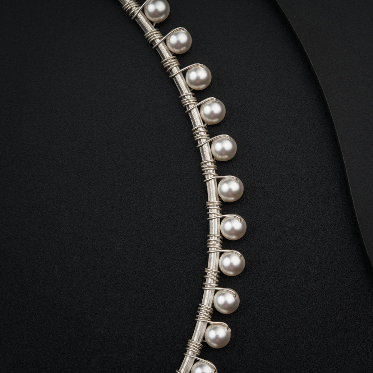 a close up of a necklace on a black surface